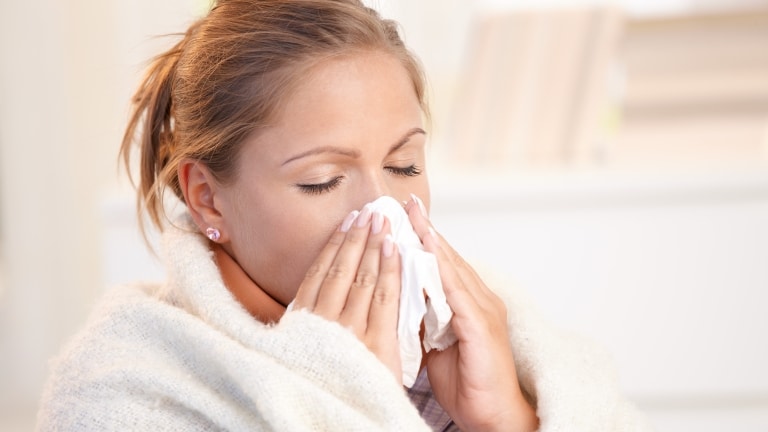 Immunsystem stärken Immunschutz mit Resisteen Frau mit Erkältung beim Nase putzen